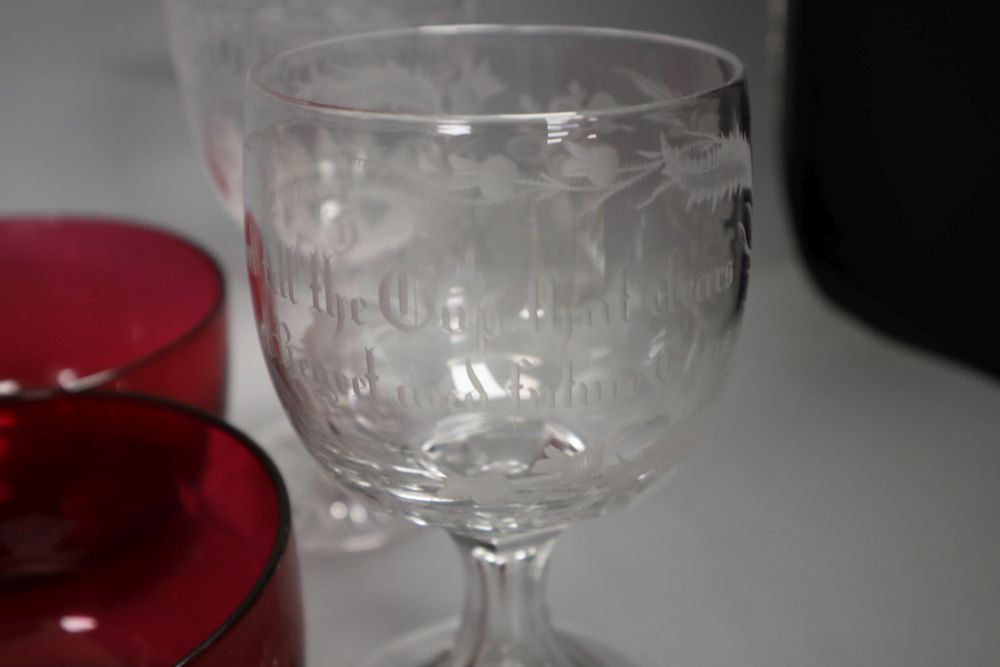 A pair of cranberry rinsers, four airtwist gilt decorated glasses, a Greek key patterned wine glass, an etched glass with motto and a v